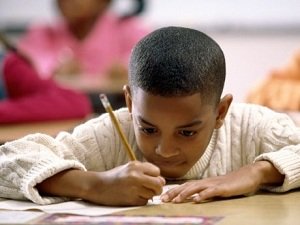 boy is writing with a pencil